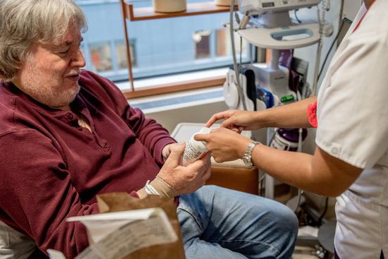 纪念斯隆-凯特琳癌症中心肿瘤科医生在给一名参加临床试验的患者检查身体